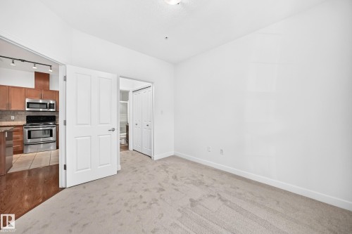 Light-colored carpeting, white walls, and a white ceiling with an attached light fixture - #307 1003 Gault Bv Nw, Edmonton, AB 