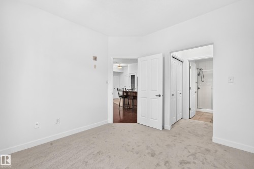 Carpeted flooring, white walls, white doors, and a tiled shower enclosure - #307 1003 Gault Bv Nw, Edmonton, AB 