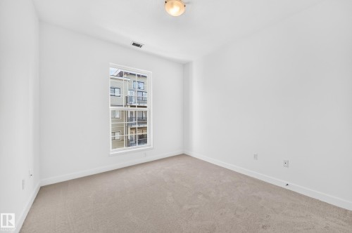 Neutral carpeting, white painted walls, and a multi-pane window - #307 1003 Gault Bv Nw, Edmonton, AB 