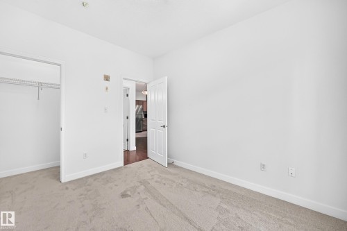 Carpeted flooring, white walls, and a closet with wire shelving - #307 1003 Gault Bv Nw, Edmonton, AB 