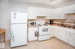 White cabinetry and appliances, tile flooring, and track lighting - 