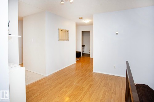 Wood-finish flooring throughout, complemented by light-toned wall finishes and recessed lighting - #407 9810 178 St Nw, Edmonton, AB 