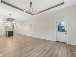 Spacious open-concept layout with wood-finish flooring, recessed ceiling lighting, and a modern kitchen island with an undermount sink - 