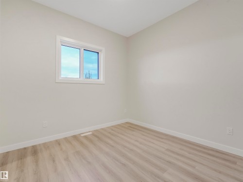 Light wood-finish flooring, white walls, and a white-framed window - 36 Dalquist Bay, Leduc, AB 