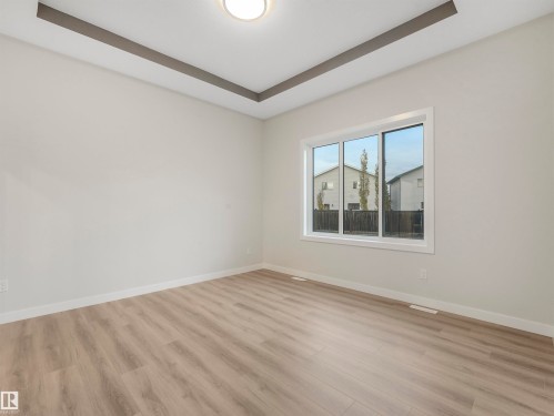 Recessed ceiling with decorative trim, flush-mount ceiling light, white walls, and wood-finish flooring - 36 Dalquist Bay, Leduc, AB 