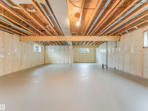 Unfinished lower level with exposed ceiling joists, concrete flooring, and multiple windows - 36 Dalquist Bay, Leduc, AB 