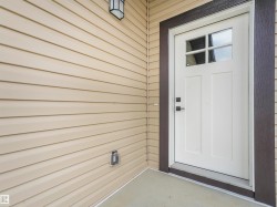 White paneled entry door with clear glass lites and dark hardware - 