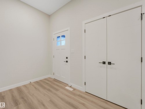 Vaulted ceiling with light-toned walls, wood-finish flooring, and white trim - 36 Dalquist Bay, Leduc, AB 