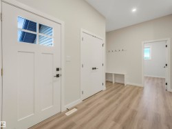 Entryway featuring wood-finish flooring, a built-in bench, and a modern front door with divided lites - 