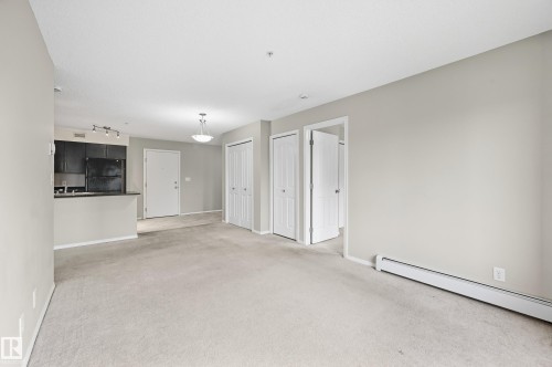 Expansive carpeted living space with light neutral wall tones - #215 11804 22 Av Sw, Edmonton, AB 