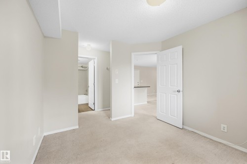 Neutral wall color, carpet flooring, flat panel interior doors, and a ceiling-mounted light fixture - #215 11804 22 Av Sw, Edmonton, AB 