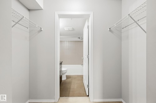 Two wire shelving units, light gray wall paint, and a white door frame - #215 11804 22 Av Sw, Edmonton, AB 