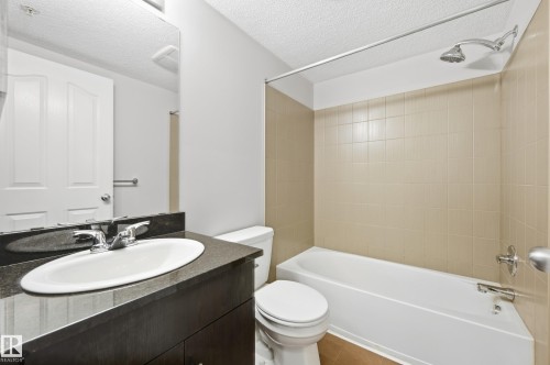 Integrated bathtub and shower with beige tiled surround - #215 11804 22 Av Sw, Edmonton, AB 