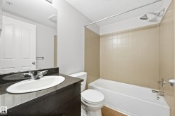 Integrated bathtub and shower with beige tiled surround - 