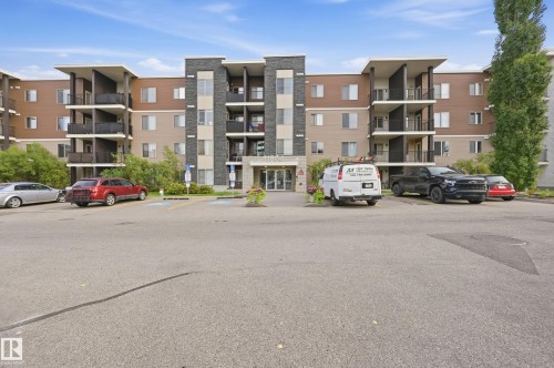 Multi-story building featuring balconies, a prominent main entrance, and exterior finishes including stone-look siding and horizontal panels - #215 11804 22 Av Sw, Edmonton, AB 