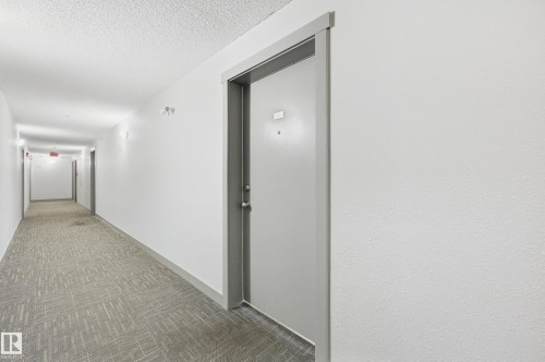 Corridor featuring patterned carpeting, white walls, and recessed lighting - #215 11804 22 Av Sw, Edmonton, AB 