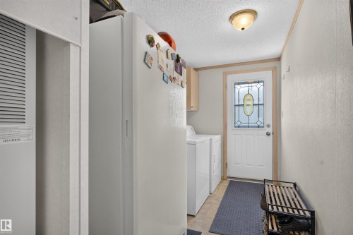 Entryway with wood-finish flooring, white paneled walls, and a white exterior door with decorative glass inlay - 1405 53222 Range Road 272, Rural Parkland County, AB 