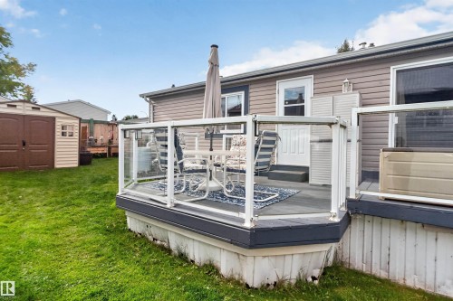 Outdoor deck with glass panel railing and composite decking, featuring a white exterior door, and vinyl siding - 1405 53222 Range Road 272, Rural Parkland County, AB 