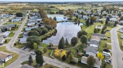 Lakeside community featuring residential properties, mature trees, and paved roads - 