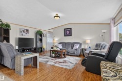 Wood-finish flooring throughout, light-toned walls, and a prominent window providing natural illumination - 