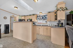 Kitchen featuring wood-finish cabinetry, solid surface countertops, a built-in breakfast bar, and a skylight - 