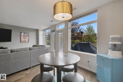 Hardwood-finish flooring, recessed lighting, and a modern drum pendant light fixture - #125 5151 Windermere Bv Sw Sw, Edmonton, AB 
