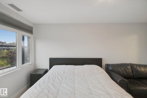 Crisp white walls, large window with roller shade, and wood-finish flooring - #125 5151 Windermere Bv Sw Sw, Edmonton, AB 