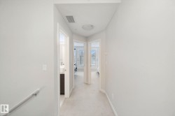 Neutral-toned walls with carpeted flooring, featuring a flush-mount ceiling light - 