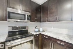 Wood-finish cabinetry paired with light-toned countertops, subway tile backsplash, and stainless steel appliances - 