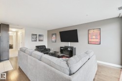 Wood-finish flooring, accent wall, built-in cabinetry, recessed lighting, ceiling-mounted television - 