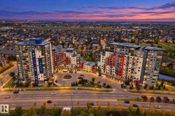 Modern high-rise architecture featuring multiple residential towers, a circular drive with landscape planting, and integrated street-level lighting - 