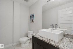 Vanity featuring a rectangular vessel sink, polished chrome faucet, and stone countertop - 