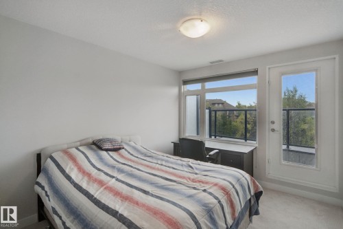 Recessed lighting, large window, glass panel balcony railing, and a private exterior door - #125 5151 Windermere Bv Sw Sw, Edmonton, AB 
