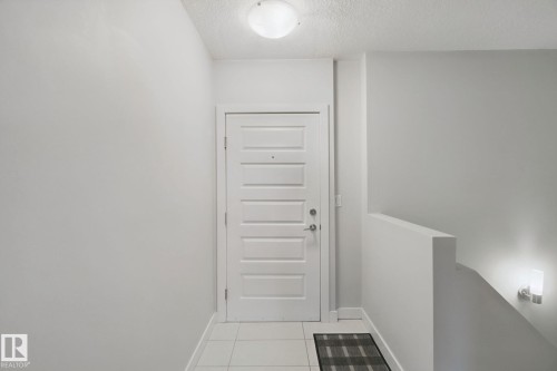 White paneled door with contemporary hardware - #125 5151 Windermere Bv Sw Sw, Edmonton, AB 
