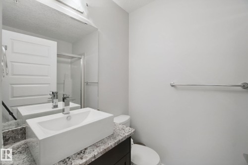 Vanity with rectangular vessel sink, stone-look countertop, and chrome fixtures - #125 5151 Windermere Bv Sw Sw, Edmonton, AB 