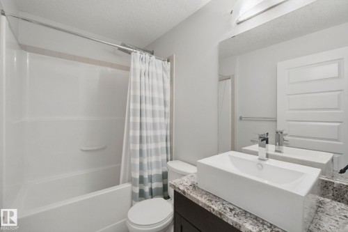 Bathroom featuring a white integrated tub and shower combination - #125 5151 Windermere Bv Sw Sw, Edmonton, AB 