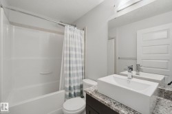 Bathroom featuring a white integrated tub and shower combination - 