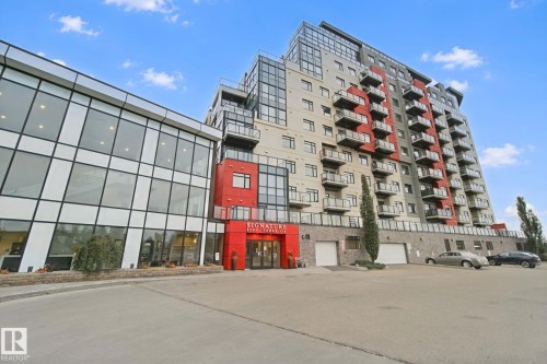 Contemporary high-rise building featuring a red entry facade, expansive glass windows, and multiple private balconies - #125 5151 Windermere Bv Sw Sw, Edmonton, AB 