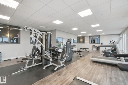 Fitness area featuring wood-finish flooring, recessed lighting, and wall-mounted mirrors - #125 5151 Windermere Bv Sw Sw, Edmonton, AB 
