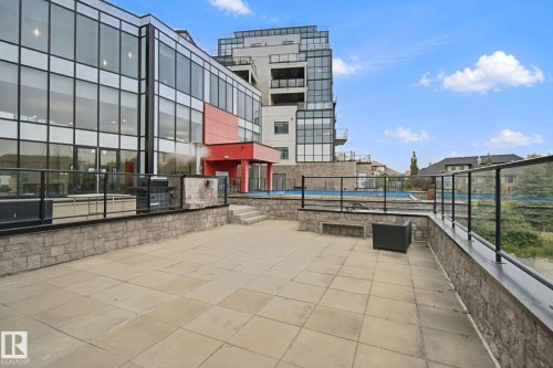 Expansive outdoor patio with stone-finish pavers and a stone-clad retaining wall - #125 5151 Windermere Bv Sw Sw, Edmonton, AB 