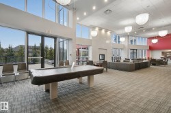 Expansive room with high ceilings, recessed lighting, and large windows - 