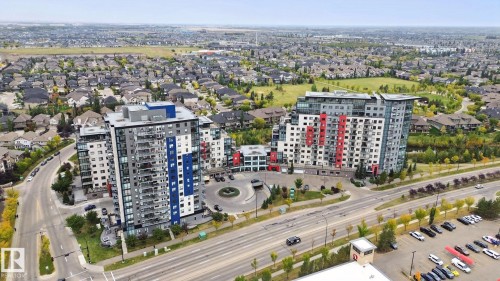 Modern high-rise buildings featuring extensive balconies and a multi-lane roadway - #125 5151 Windermere Bv Sw Sw, Edmonton, AB 