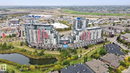 Modern multi-story building featuring varied facade treatments, integrated residential units, and a central courtyard - #125 5151 Windermere Bv Sw Sw, Edmonton, AB 