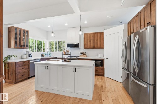 White kitchen island with shaker-style cabinetry and black hardware - #45 53122 Rge Road 14, Rural Parkland County, AB 