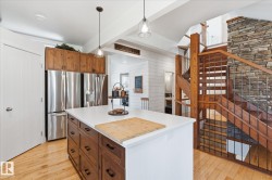 Kitchen island with white countertop, wood-finish cabinetry, and stainless steel appliances - 