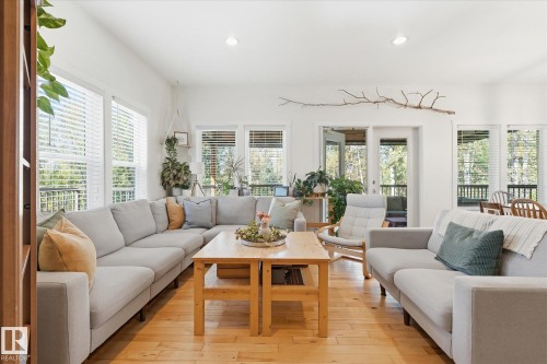 Spacious living area featuring light wood-finish flooring, numerous windows with horizontal blinds, recessed lighting, and a white interior paint scheme - #45 53122 Rge Road 14, Rural Parkland County, AB 