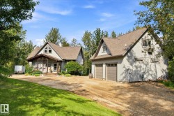 Gable-roof property featuring a covered porch, an attached two-car garage, and a separate detached two-car garage - 