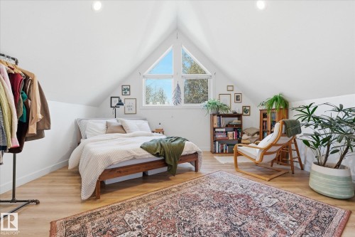Vaulted white ceilings, wood-finish flooring, a prominent triangular window, recessed lighting, and built-in shelving - #45 53122 Rge Road 14, Rural Parkland County, AB 