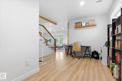 Wood-finish flooring throughout, with a built-in wood shelf, recessed lighting, and a visible staircase featuring wooden handrails - #45 53122 Rge Road 14, Rural Parkland County, AB 