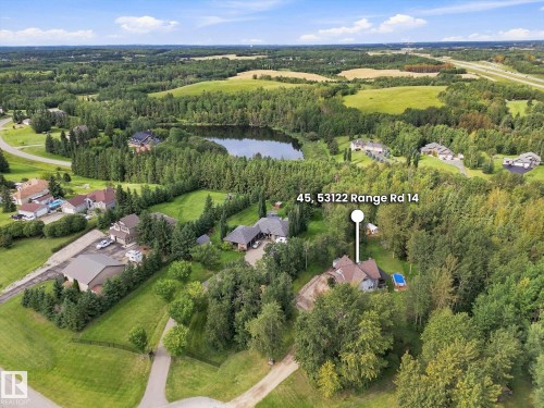 Expansive residential property with mature trees, a private pool, and a structured driveway, surrounded by a natural landscape - #45 53122 Rge Road 14, Rural Parkland County, AB 